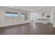 Bright living room with sleek hardwood floors, large windows, and an open layout leading to a modern kitchen at 17134 W Hackamore Dr, Surprise, AZ 85387