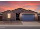 Beautiful single-story home with a two-car garage, stone accents, and desert landscaping at sunset at 4323 W Josephine St, San Tan Valley, AZ 85144