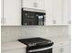 Close-up of the kitchen showcasing a stainless steel range hood, backsplash, and modern appliances at 4323 W Josephine St, San Tan Valley, AZ 85144