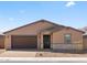 Single-story home with a brick driveway, two-car garage, desert landscaping, and accents of stone veneer at 4919 W Hunter Trl, San Tan Valley, AZ 85144