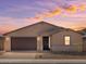 Charming single-story home with a brick driveway, two-car garage, and desert landscaping against a beautiful twilight sky at 4919 W Hunter Trl, San Tan Valley, AZ 85144