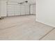 A spacious garage featuring a white garage door, smooth concrete flooring, and ample space at 4919 W Hunter Trl, San Tan Valley, AZ 85144