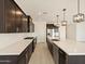 Contemporary kitchen with stainless steel appliances, dark cabinets, and quartz countertops at 4919 W Hunter Trl, San Tan Valley, AZ 85144
