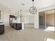 Open-concept kitchen with stainless steel appliances, an island with seating, and modern light fixtures at 4919 W Hunter Trl, San Tan Valley, AZ 85144
