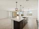 Open kitchen with center island, eat in bar, pendant lighting and sliding patio door at 4919 W Hunter Trl, San Tan Valley, AZ 85144