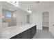 Bathroom featuring a double vanity with gray cabinets and a tiled shower enclosure at 25137 N 171St Ave, Surprise, AZ 85387