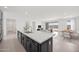 Open-concept kitchen with dark cabinets, large island, and a view of the living and dining areas at 25137 N 171St Ave, Surprise, AZ 85387