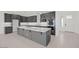 Modern kitchen featuring gray cabinets, a large island, and an open layout leading to the entryway at 25137 N 171St Ave, Surprise, AZ 85387