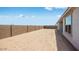 Expansive dirt backyard, enclosed by a tall block wall, offering privacy and potential for landscaping at 25149 N 171St Ave, Surprise, AZ 85387