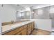 Modern bathroom with double sinks, wooden cabinets, and a large mirror at 25149 N 171St Ave, Surprise, AZ 85387