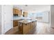 Well-lit kitchen with a large island, wood-look tile flooring, and stainless steel appliances at 25149 N 171St Ave, Surprise, AZ 85387