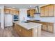 Bright kitchen with an island, stainless steel appliances, light wood cabinets, and a tile backsplash at 25149 N 171St Ave, Surprise, AZ 85387