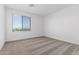 Bedroom with a large window allows for natural light, enhancing the neutral color scheme and carpet at 8552 N 170Th Ln, Waddell, AZ 85355