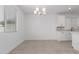 Bright dining room features neutral tile floors, modern chandelier, and white cabinets, ideal for Gathering meals and gatherings at 8552 N 170Th Ln, Waddell, AZ 85355