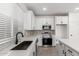 Modern kitchen with stainless steel appliances, white cabinets and large black sink at 8552 N 170Th Ln, Waddell, AZ 85355