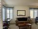 Cozy living room featuring plush seating, a decorative mirror, and bright natural light from shuttered windows at 1095 W Desert Valley Dr, San Tan Valley, AZ 85143