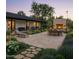Beautiful backyard patio with a stone fireplace, outdoor seating, dining area, and lush landscaping at 88 N Country Club Dr, Phoenix, AZ 85014