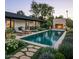 Stunning backyard pool with a stone fireplace, lounge chairs, and lush landscaping at 88 N Country Club Dr, Phoenix, AZ 85014