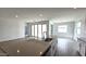 Large kitchen island featuring a sink, dishwasher, and quartz countertops with wood-look tile flooring at 37600 N Cowboy Ln, San Tan Valley, AZ 85140