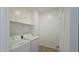 Well-lit laundry room with white walls, modern washer and dryer, and convenient shelving at 37600 N Cowboy Ln, San Tan Valley, AZ 85140