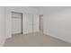 Bright bedroom with neutral carpet, white walls and a closet featuring sliding doors and closet rods at 7449 S 75Th Dr, Laveen, AZ 85339