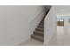 Carpeted stairs ascend with a white handrail, leading to a bright, open space with tile flooring at 7449 S 75Th Dr, Laveen, AZ 85339