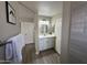 Bathroom view shows double sinks, white cabinets, a toilet, and wood floors at 15075 W Amelia Dr, Goodyear, AZ 85395