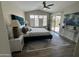 Bright main bedroom features a plush bed, sliding door to patio and a ceiling fan at 15075 W Amelia Dr, Goodyear, AZ 85395