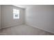 Cozy bedroom with neutral carpet, a window, and ample natural light at 40010 W Bravo Dr, Maricopa, AZ 85138