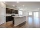 Open-concept kitchen featuring dark cabinets, stainless steel appliances, and a central island at 40010 W Bravo Dr, Maricopa, AZ 85138