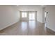 Spacious living room with wood-look tile flooring and ample natural light from sliding glass doors at 40010 W Bravo Dr, Maricopa, AZ 85138