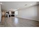 Expansive living space with wood-look tile flooring, leading to the kitchen and dining areas at 40010 W Bravo Dr, Maricopa, AZ 85138