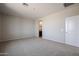 Main bedroom with carpet flooring, neutral paint, and bathroom entrance at 40010 W Bravo Dr, Maricopa, AZ 85138