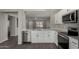 Modern kitchen with white cabinets, stainless steel appliances, and quartz countertops at 574 W Kingman Dr, Casa Grande, AZ 85122