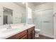Bathroom with double sink vanity, framed mirror, and glass shower enclosure at 26058 W Yukon Dr, Buckeye, AZ 85396
