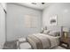 Cozy bedroom featuring neutral colors, a comfortable bed, side tables with lamps, and a window with blinds at 26058 W Yukon Dr, Buckeye, AZ 85396
