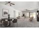 Bright, open-concept living room with neutral decor, ceiling fans, and sliding glass doors to the backyard at 26058 W Yukon Dr, Buckeye, AZ 85396