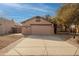 Tan house with a two-car garage and landscaped yard at 3011 E Colonial Pl, Chandler, AZ 85249