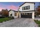 Two-story modern farmhouse with gray paver driveway, landscaping, and dark garage door at 7240 N 13Th Ln, Phoenix, AZ 85021
