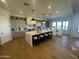 Spacious open-concept kitchen featuring an island with seating, pendant lighting and stainless steel appliances at 25219 S 194Th St, Queen Creek, AZ 85142