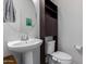Clean bathroom with pedestal sink, toilet and storage cabinet at 3714 S 58 Dr, Phoenix, AZ 85043