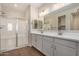 Modern bathroom with double vanity, large mirror, and walk-in shower at 17862 W Blue Sky Dr, Surprise, AZ 85387