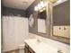 Bathroom featuring double sinks, stylish mirrors, and a shower/tub combo with a patterned shower curtain at 2116 N 81St Cir, Mesa, AZ 85207