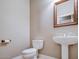 Powder room featuring a pedestal sink, toilet, and framed mirror at 2116 N 81St Cir, Mesa, AZ 85207