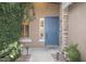 Close-up of a blue front door, with stone accents, flanked by greenery and outdoor lighting at 2116 N 81St Cir, Mesa, AZ 85207