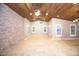 Large great room with a stone accent wall, wood plank ceiling, and ample natural light at 2116 N 81St Cir, Mesa, AZ 85207
