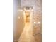 Hallway featuring a stone accent wall, neutral colors, and tile flooring at 2116 N 81St Cir, Mesa, AZ 85207