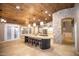 Open kitchen with a large island, wood plank ceiling, and modern appliances at 2116 N 81St Cir, Mesa, AZ 85207