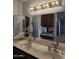 Bathroom vanity featuring double sinks, granite countertops, and dark wood cabinetry at 402 W Grandview Rd, Phoenix, AZ 85023
