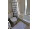 Cozy bathroom featuring a white tiled shower-tub, toilet, and decorative curtain at 402 W Grandview Rd, Phoenix, AZ 85023
